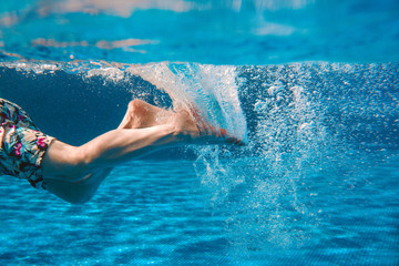 Men's legs swimming underwater in the swimming pool in summer © k8most