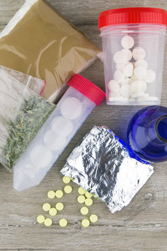 drug detection: samples of packaged drugs next to the flask of liquid indicator solution on the inspection table of the customs laboratory, in short focus, top view