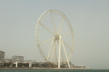 Construction of the largest Ferris wheel by the sea. The style is retro. Sandstorm. Dubai, March, 2018.