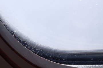 Obraz premium Frozen porthole in the plane. Background.