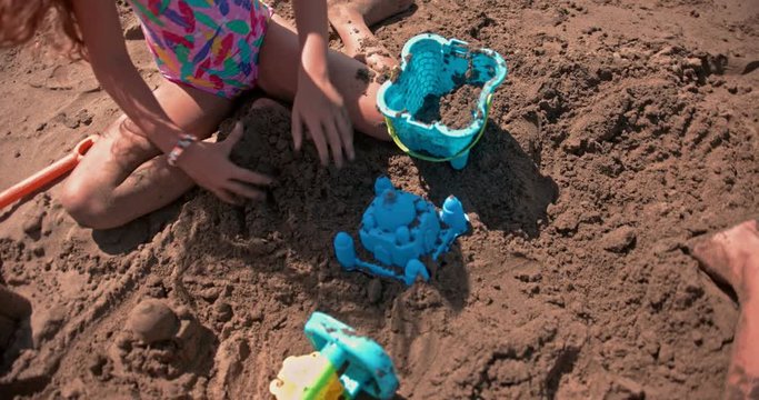 Young children building sancastles on beach on summer holidays