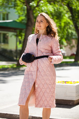 Portrait of a young beautiful woman in pink coat