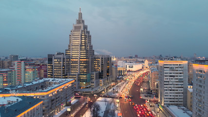 Aerial shooting of Moscow Garden Ring in the evening with camera going up. City lights in the dusk. Business center "Oruzheiny" tower at sunset.