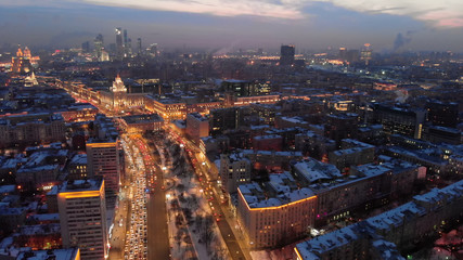 Fototapeta na wymiar Aerial shooting of Moscow Garden Ring in the evening. City lights in the dusk. Business center 