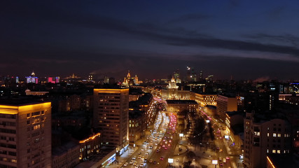 Fototapeta na wymiar Aerial shooting of Moscow Garden Ring at night. City lights and intensive traffic on the highway. Panoramic cityscape with illuminated buildings.