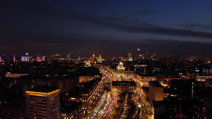Aerial shooting of Moscow Garden Ring at night. City lights and intensive traffic on the highway. Panoramic cityscape with illuminated buildings.