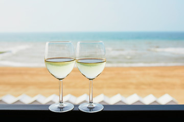 Two glasses of white wine with Atlantic coast beach in background