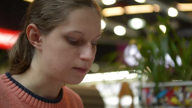 Pregnant woman eating cake at the mall cafe