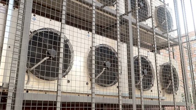 Industrial air conditioning sustem on the wall outdoors. Rotating large industrial fans.