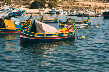Fototapeta na wymiar Classic maltese boats, view to bay of Marsaxlokk