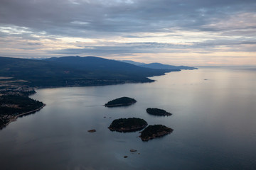 Aerial view of Sunshine Coast during a vibrant cloudy sunset. Located Northwest of Vancouver, British Columbia, Canada.