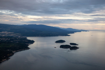 Aerial view of Sunshine Coast during a vibrant cloudy sunset. Located Northwest of Vancouver, British Columbia, Canada.