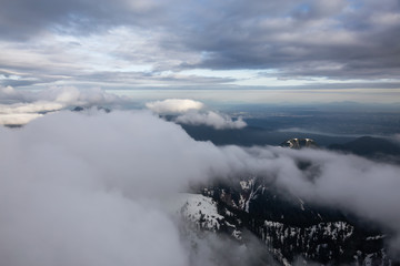 Aerial view of the striking Canadian Mountain Landscape covered in clouds. Taken North of Vancouver, British Columbia, Canada.