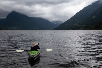 Fototapeta na wymiar Adventurous Man on a Kayak is enjoying the beautiful Canadian Mountain Landscape. Taken in Jones Lake, near Chilliwack and Hope, East of Vancouver, BC, Canada.
