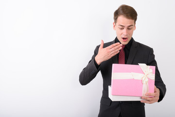 Young handsome businessman wearing suit against white background