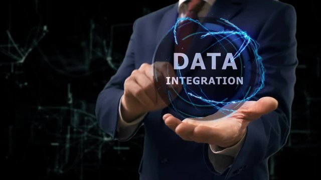 Businessman shows concept hologram Data integration on his hand. Man in business suit with future technology screen and modern cosmic background