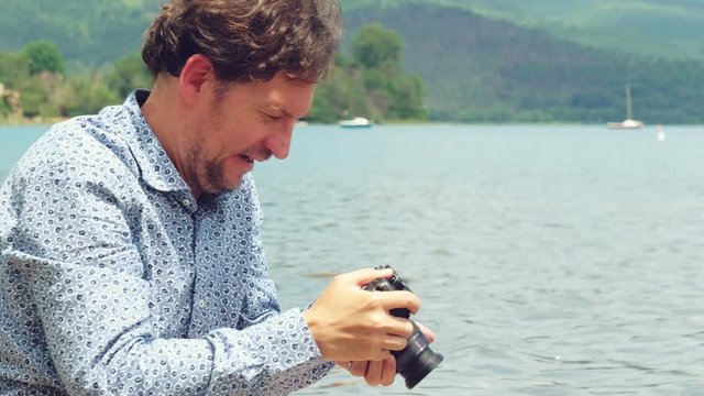 Man in front of lake in vacation taking pictures to nature and animals closeup