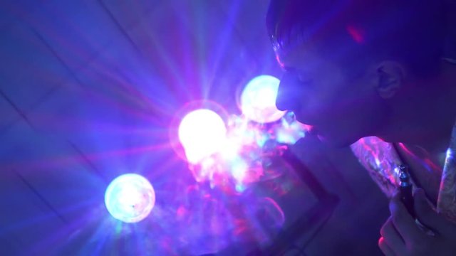 hookah smoking - the guy exhales smoke in the bright spotlights
