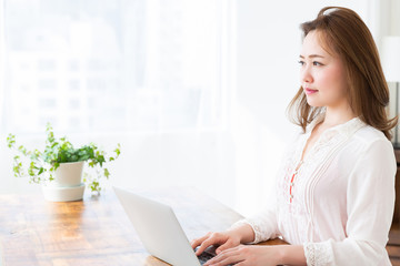 部屋でラップトップコンピューターを見る女性