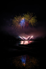 Beautiful colorful fireworks display on celebration night Celebration fireworks over the river with cityscape soft focus background at night scene