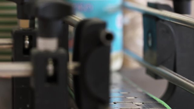Modern milk production line. Fresh milk products labeling at dairy factory. Close up packing milk bottles in slow motion