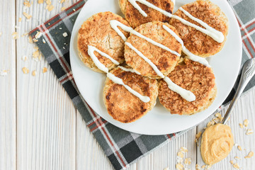 Oat cottage cheese pancakes with sour cream and peanut butter on white wooden background. Healthy breakfast, snack or diner.