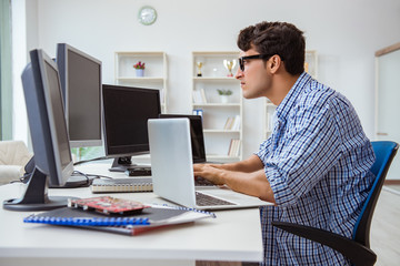 Businessman sitting in front of many screens