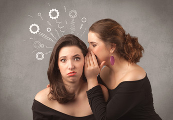 Two girlfriends in elegant black dress sharing secrets with each other concept with drawn rack cog wheels and spiral lines on the wall background.