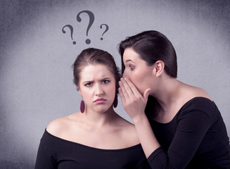 A teenager girl looking confused with drawn question marks above the head, while a girlfriend whispers something in her ear concept.