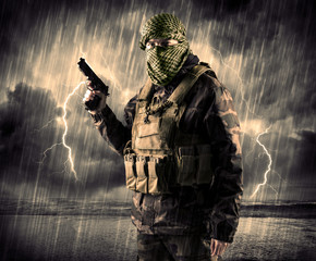 Portrait of a dangerous armed terrorist with mask and gun in a thunderstorm with lightning