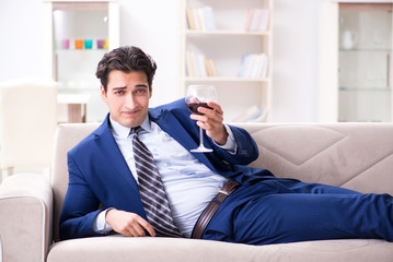 Businessman drinking wine sitting at home