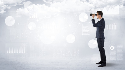 Businessman looking forward with binoculars cloudy background and graphs, charts around
