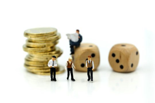 Miniature people businessman meeting with stack of coins and dices, risk of business concept.