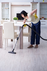 Senior old woman tired after vacuum cleaning house