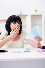 Mature woman trying to reconcile her bills