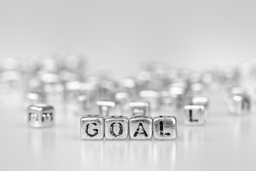 Goal word written on silver cube  with black and white bokeh cube word block background