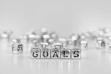 Goals word written on silver cube  with black and white bokeh cube word block background