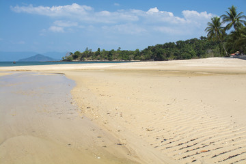 Sand beach with green sea water and blue sky. Islands in Andaman Sea, Thailand.