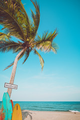 Vintage surf board with palm tree on tropical beach in summer. vintage color tone