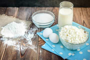 Ingredients for cooking curd pancakes top view. Eggs, cottage cheese, sugar, milk and flour.