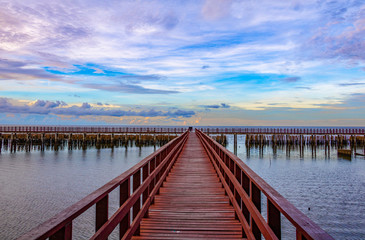 Fototapeta premium In the morning The red bridge and sun up or sun set on horizon. bridge cross sea in to the forest Thailand .Photo concept for Thailand landscape .