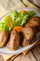 Tuna Patties with potatoes and spices h fresh salad closeup on a plate. vertical