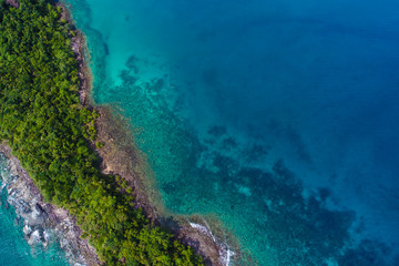 Rocky island sea beach with green tree aerial view