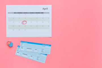 Plan a trip. Buy airplane tickets. Tickets near calendar with date circled on pink background top view copy space