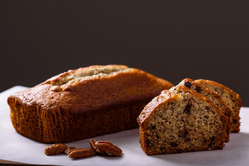 Banana Bread with slices and pecans isolated on a dark background