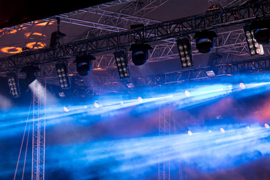 stage scene during performance. blue lights of projectors and smoke above the stage