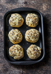 Homemade cheese buns on a baking tray on a wooden background, top view