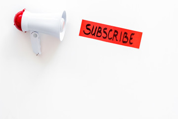 Subscribe template or mockup. Hand lettering subcribe near megaphone on white background top view space for text