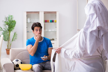 Obraz premium Young wife is trying to seduce husband from watching football an