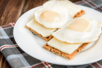 Healthy sandwiches with soft cheese and egg on crisp rye bread on dark wooden background. Breakfast or snack.